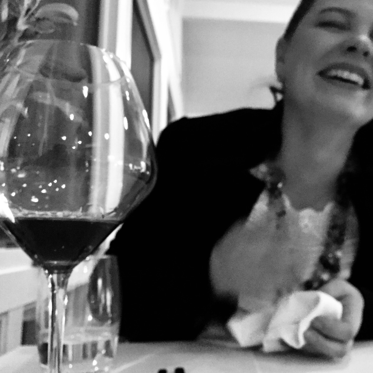 Friends laughing over a glass of wine, celebrating
