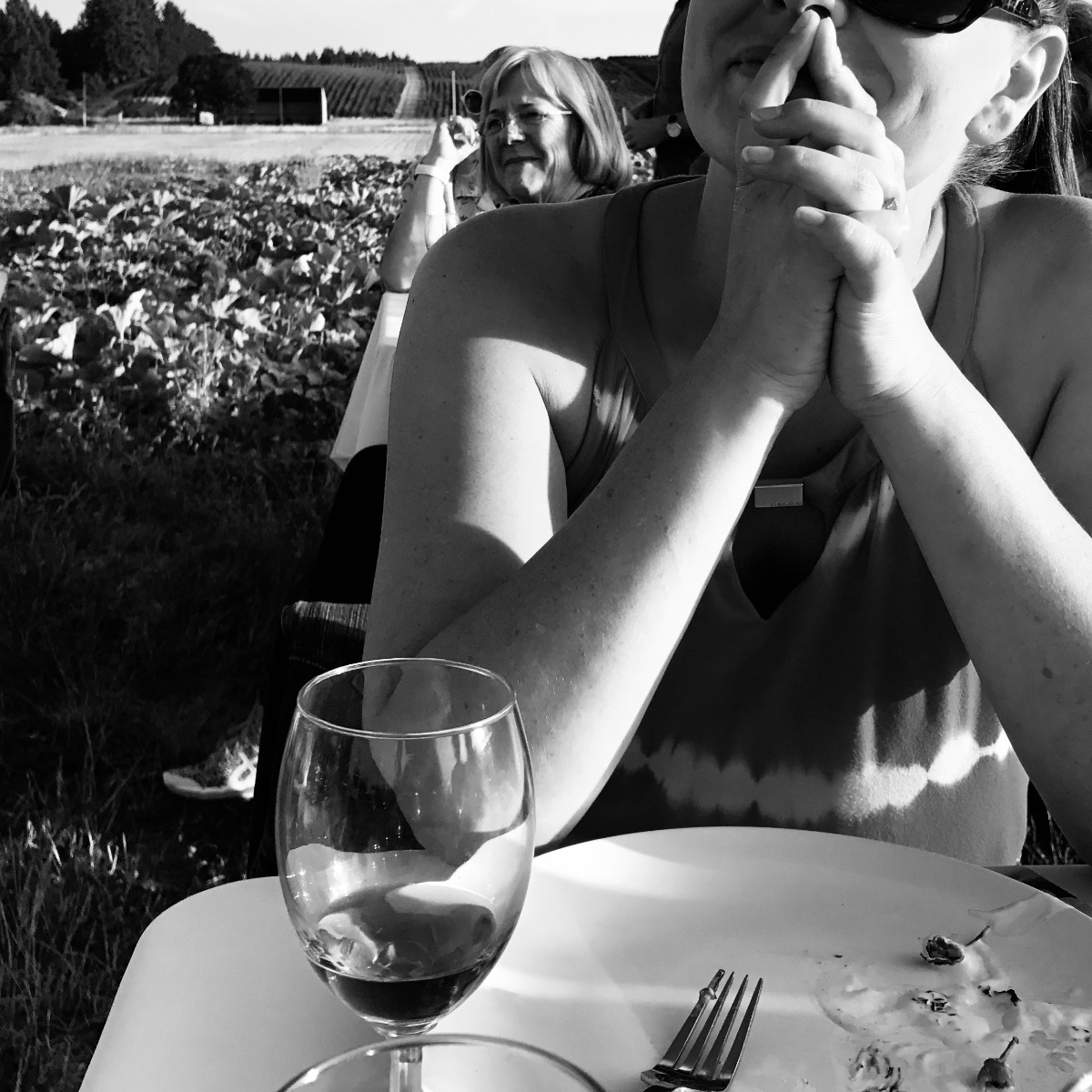 Friends at a table among the vines in the Willamette Valley